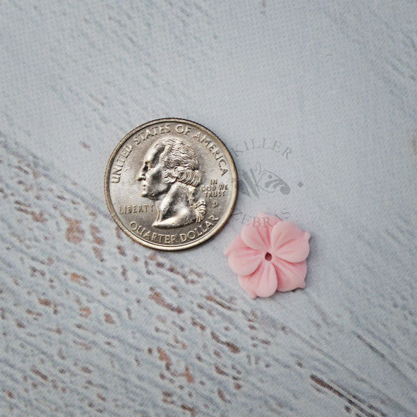 small blue silicone flower moldnext to pink fondant flower